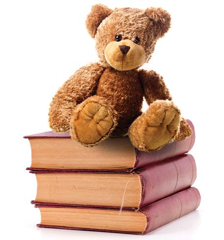 tedde bear seated on top of 3 old books