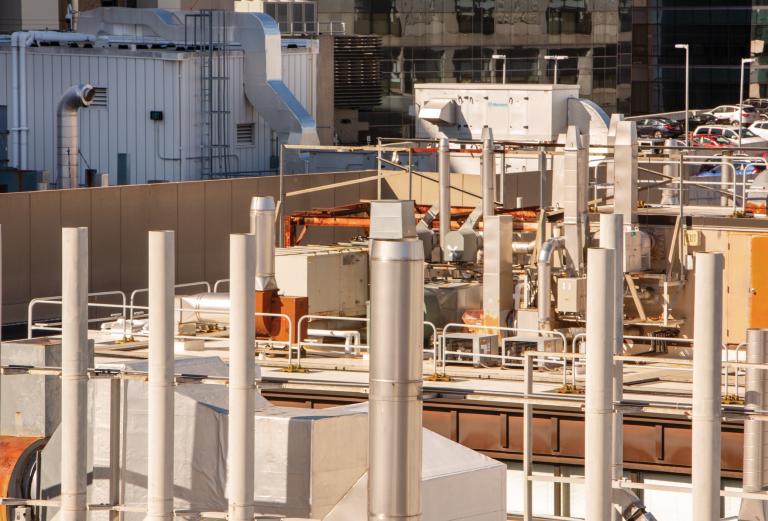 A view of a rooftop with a complex maze of stacks