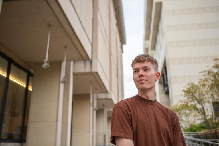 Sam Steuart stands outside of a building at HMS