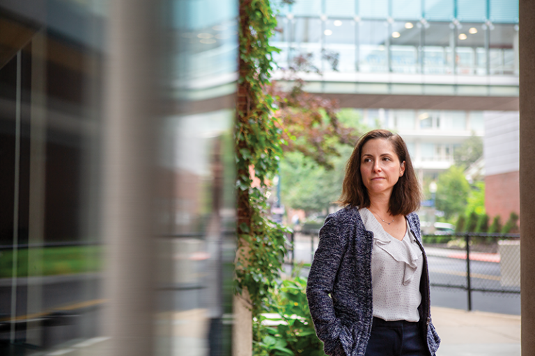 Ann-Marie Anagnostopoulos stands outside a building with an overpass next to the street