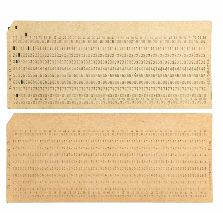 Two weathered, beige pieces of paper with a series of typed numbers