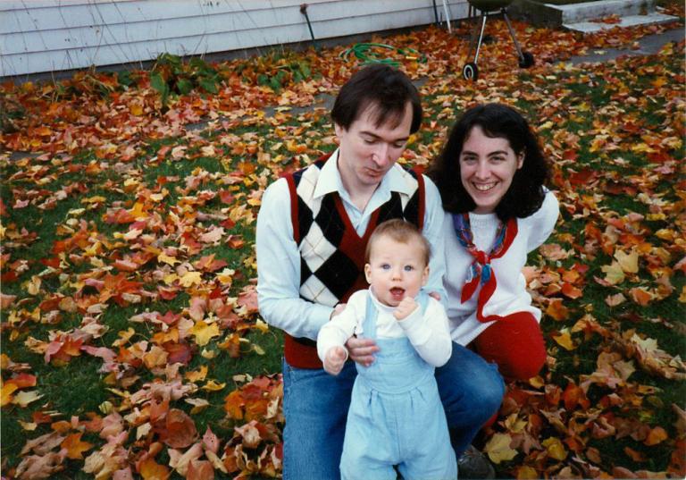 Gordon Freeman and Arlene Sharpe with a child outside with leaves on the ground around them.