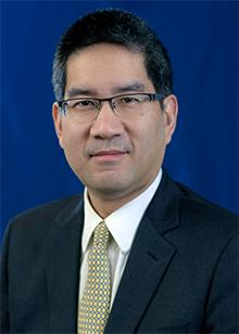 Richard Wong against a blue background