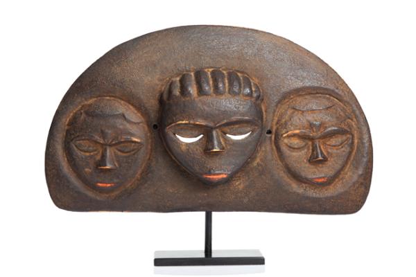 Three mask-like faces on a half-moon sculpture fixed on a pedestal 