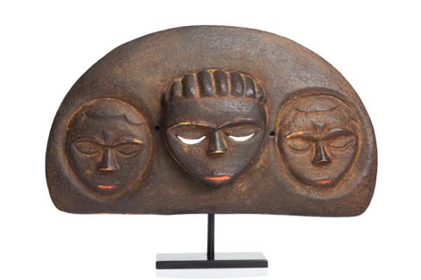 Three mask-like faces on a half-moon sculpture fixed on a pedestal