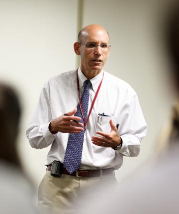 A man speaks to a class in a lecture room