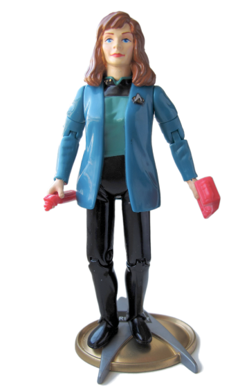 A plastic figurine of a woman in a blue Star Trek uniform, Dr. Crusher 